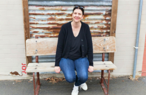 Linda Cull sitting on a rustic bench in Collie, WA